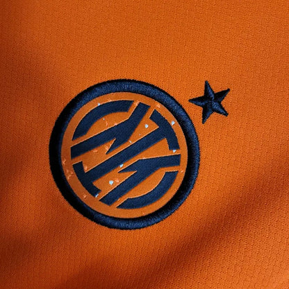 Inter Milan x Stussy Limited Edition Jersey in vibrant orange, featuring the Inter Milan crest and Stussy logo, blending football heritage with streetwear style.