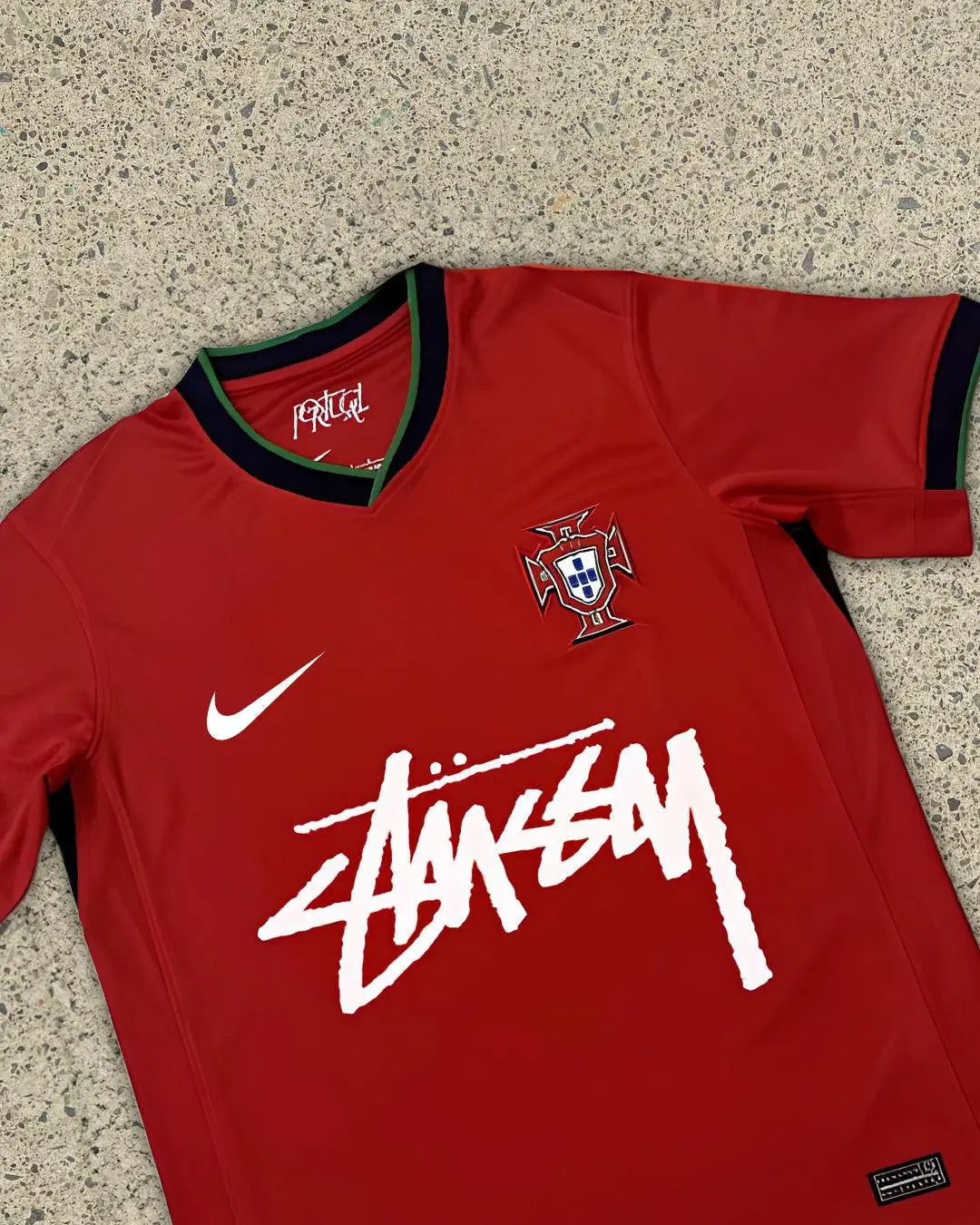 Stussy Portugal Edition Jersey featuring vibrant red and green colors, Stussy branding, and the Portugal national crest, celebrating the fusion of streetwear and football.